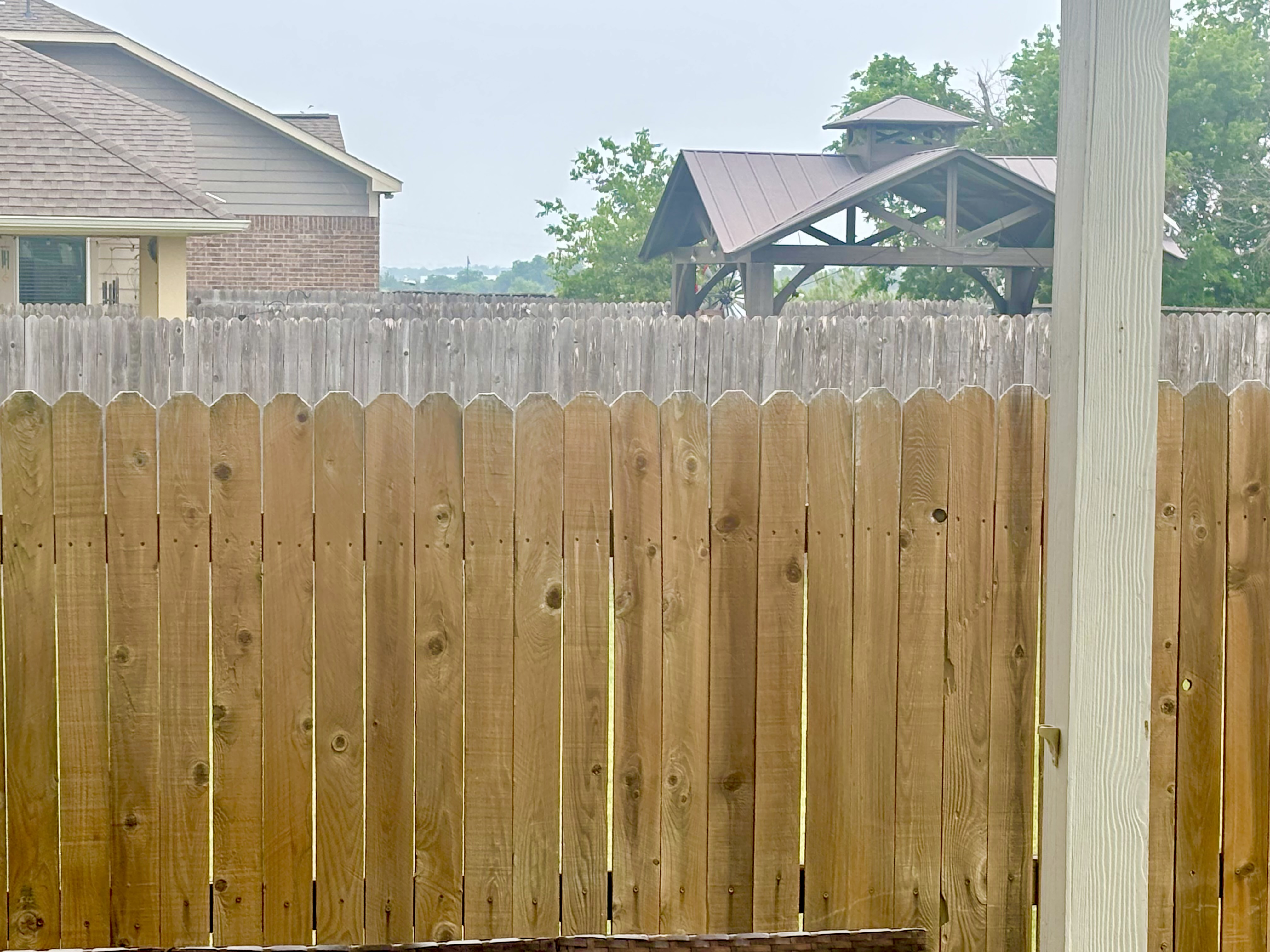 Treated fence versus untreated neighbor fence in background